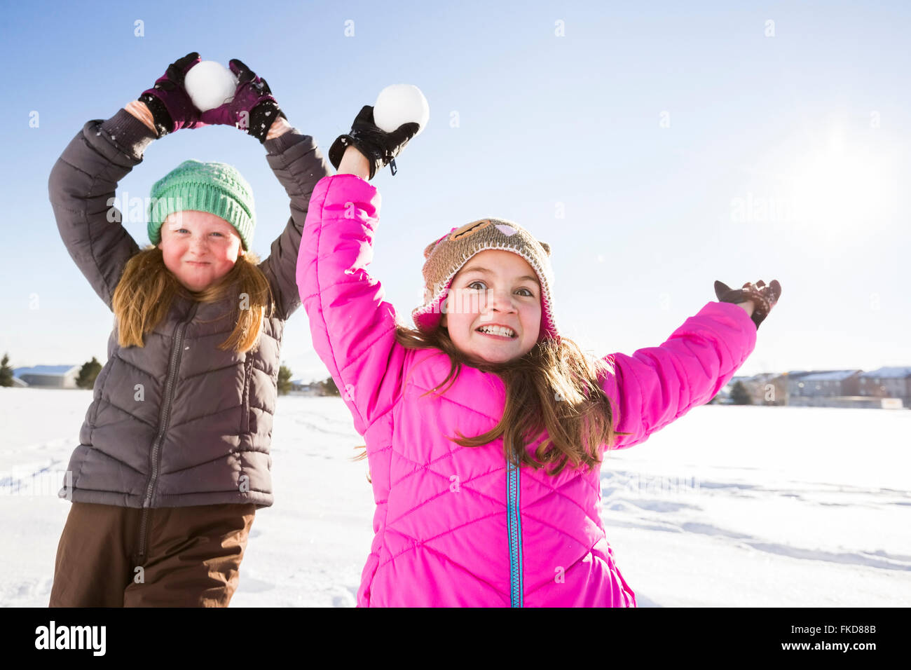 Mädchen (8-9, 10-11) spielen mit Schneebällen Stockfoto