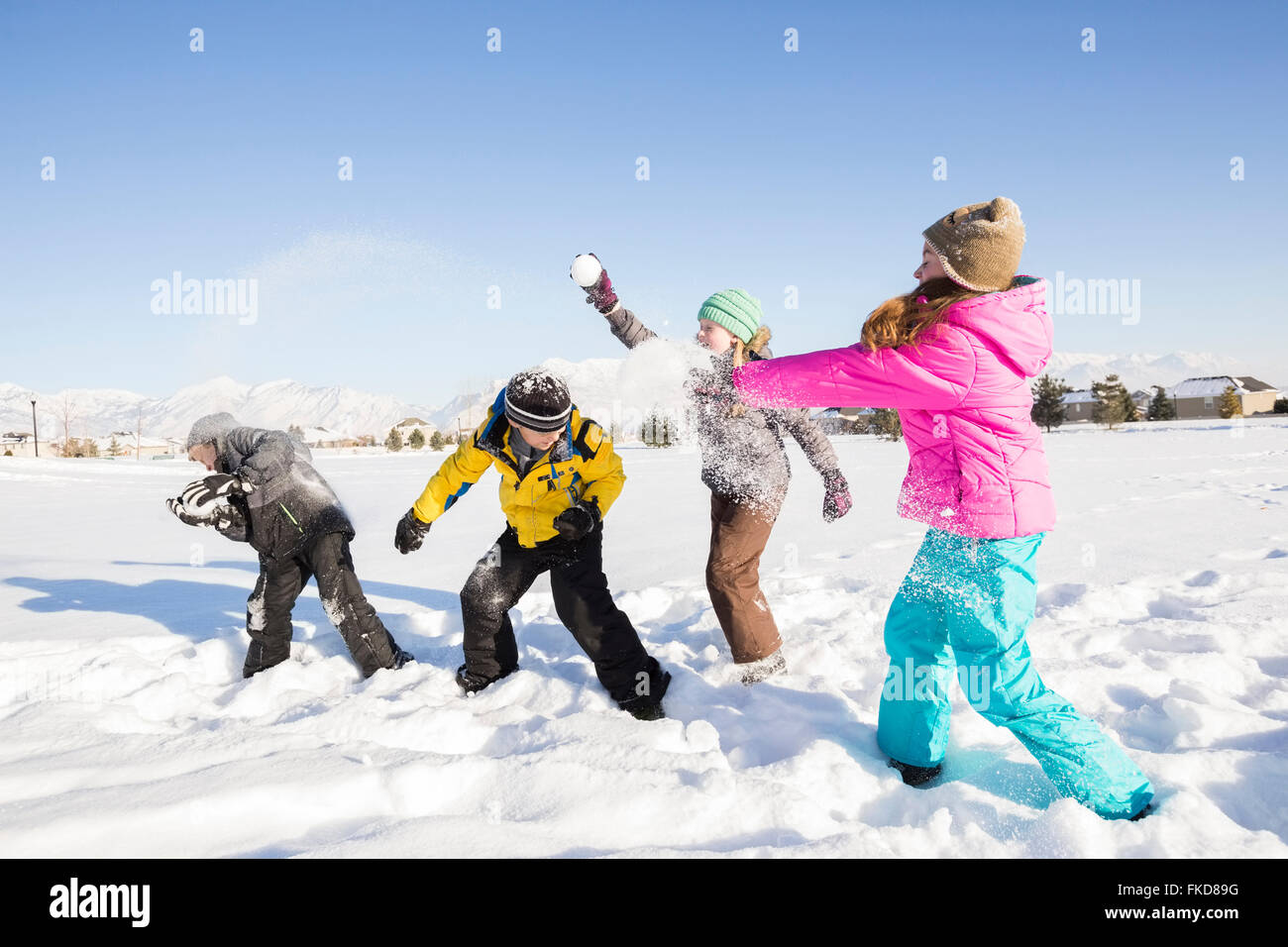 Kinder (8-9, 10-11) spielen im Schnee Stockfoto