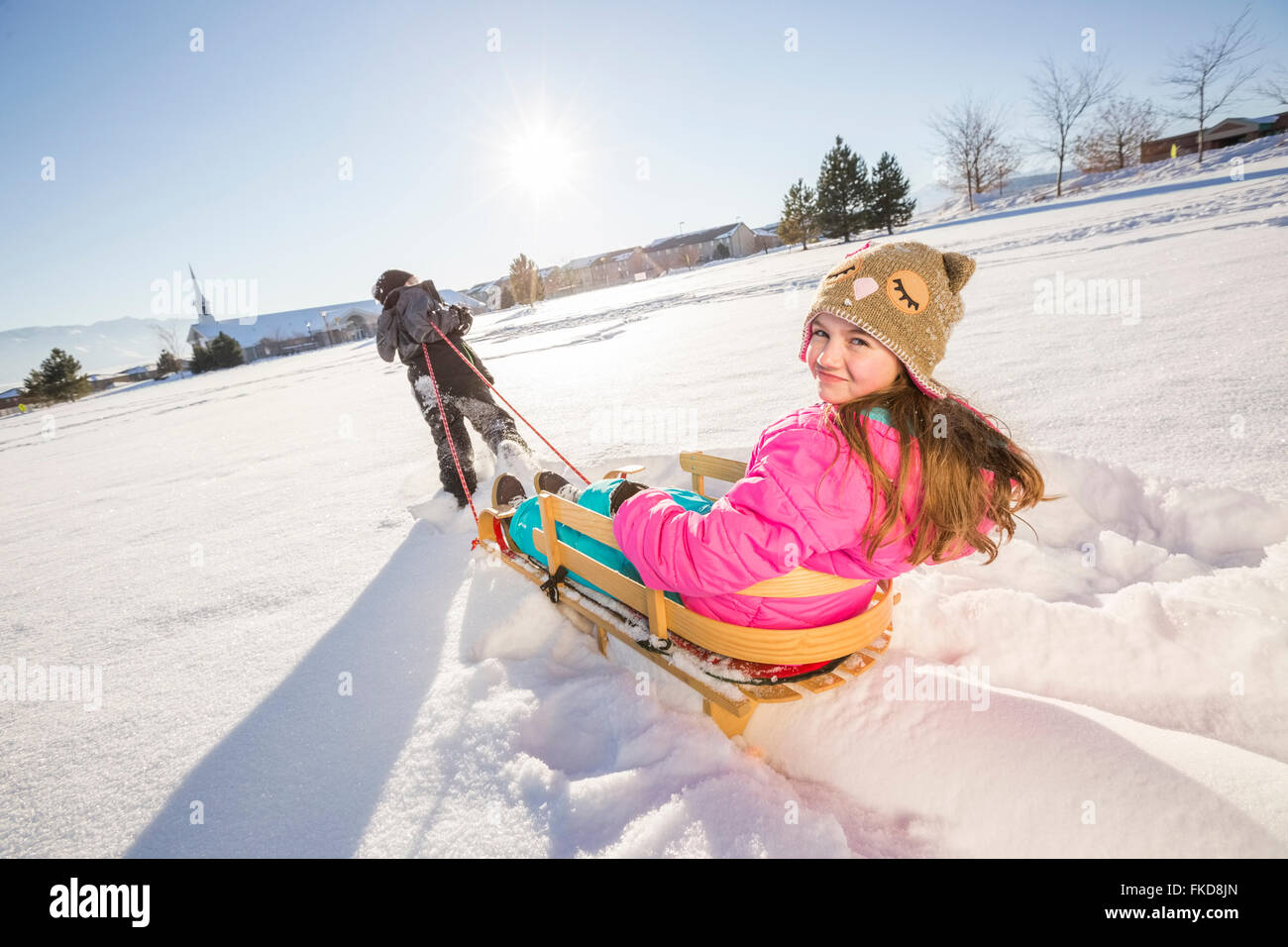 Kinder (8-9, 10-11) mit Schlitten im Schnee spielen Stockfoto