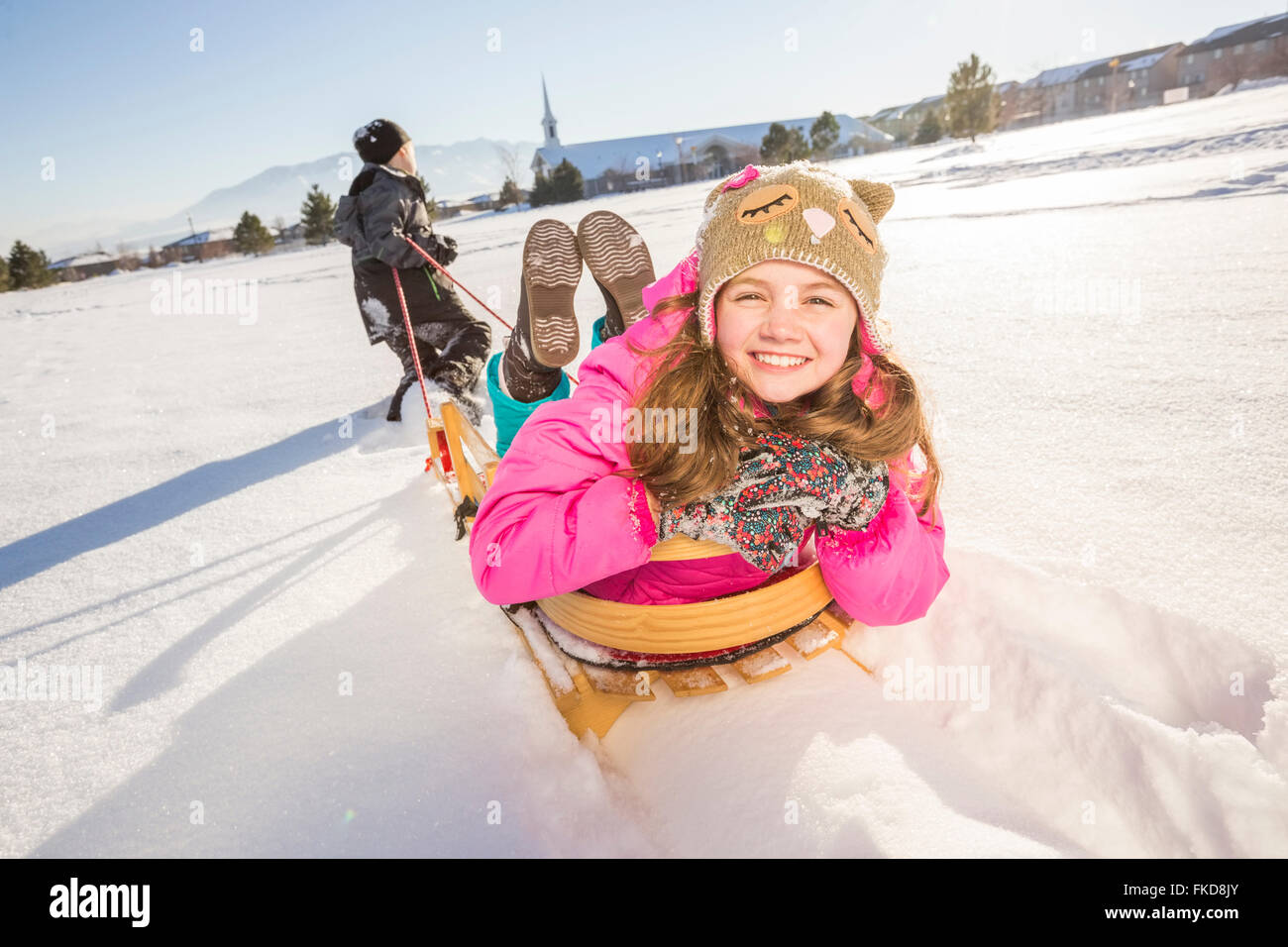 Kinder (8-9, 10-11) mit Schlitten im Schnee spielen Stockfoto