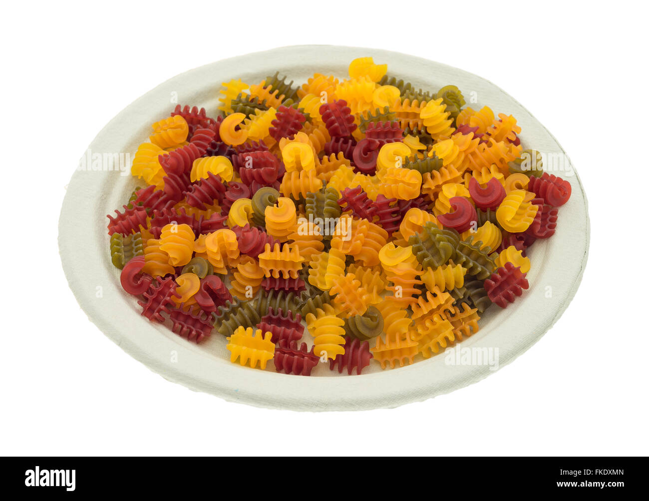 Seitenansicht des Gluten freie Mais Gemüse Radiatore Pasta auf einen Pappteller isoliert auf einem weißen Hintergrund. Stockfoto
