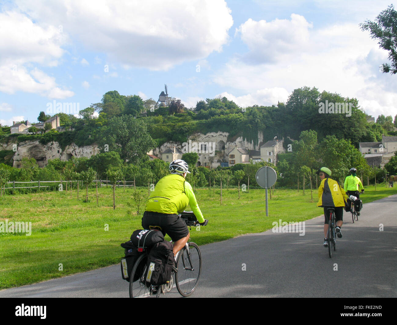 Drei Touren-Radfahrer fahren auf eine Sammlung von Höhlenwohnungen. Stockfoto