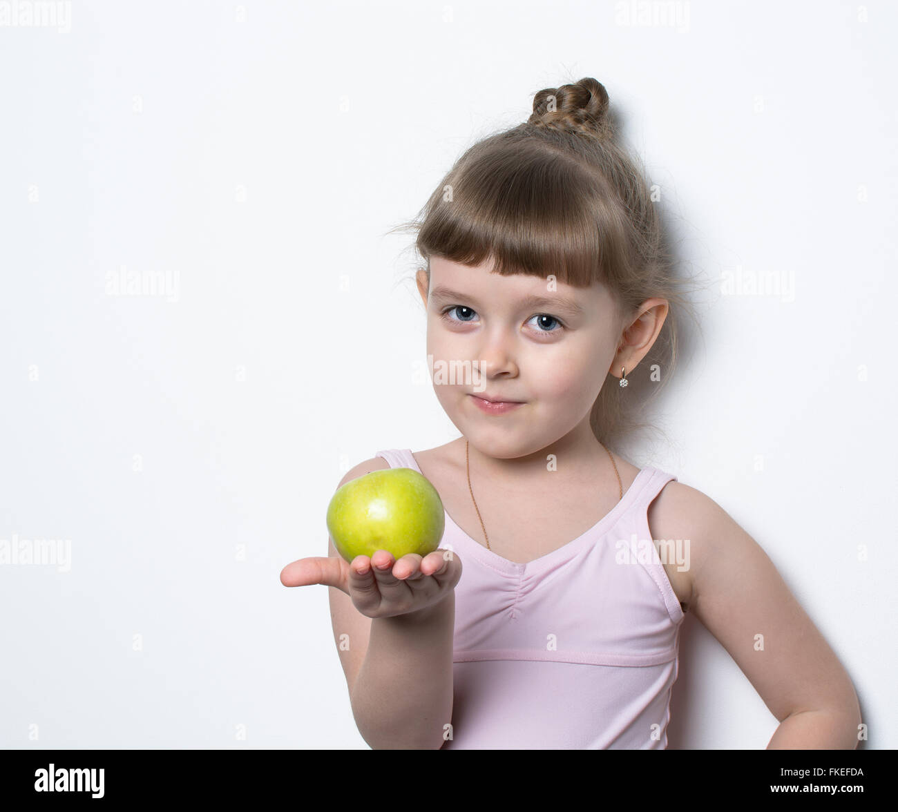 kleine Ballerina in rosa Kleid mit frischen Apfel Stockfoto