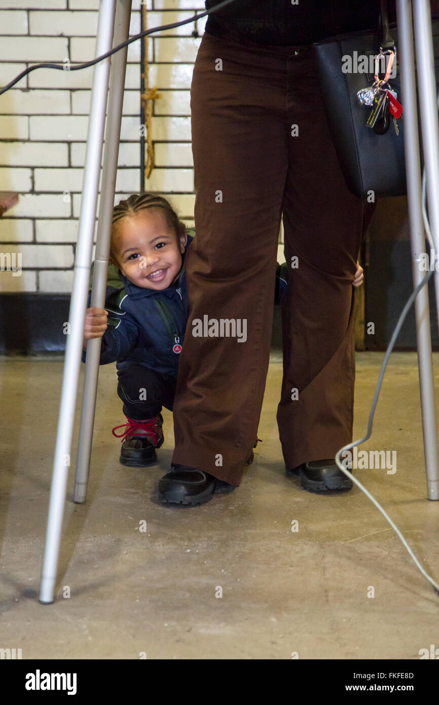 Detroit, Michigan, USA. 8. März 2016. Ein Kleinkind wartet, während seine Mutter ihre Stimmzettel in primären Präsidentschaftswahl Michigans markiert. Bildnachweis: Jim West/Alamy Live-Nachrichten Stockfoto