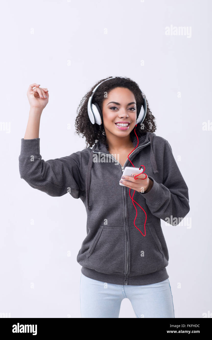 Positiven Mulatte Frau anhören von Musik Stockfoto