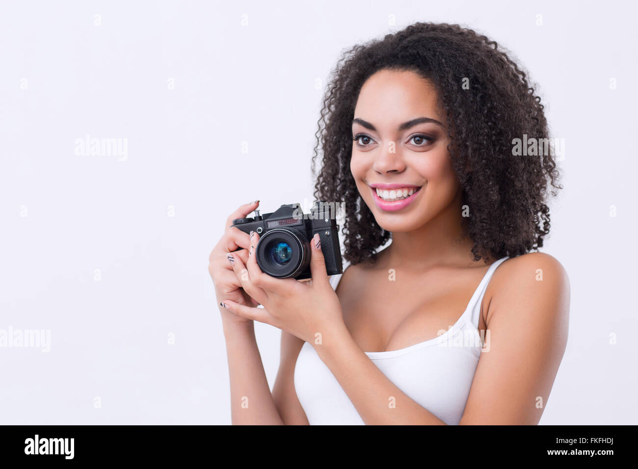 Fröhliche Mulatte Frau mit Fotokamera Stockfoto