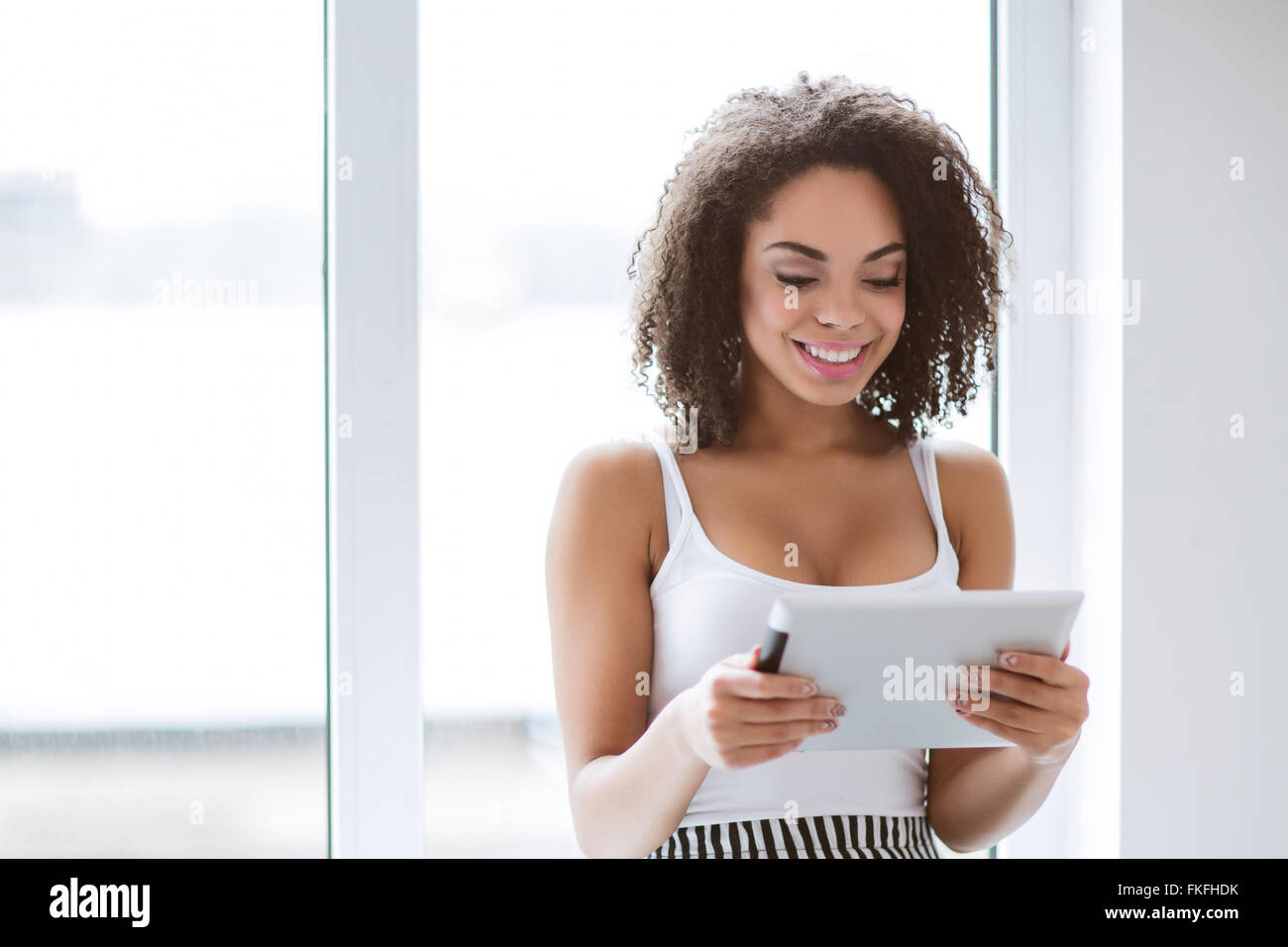 Lächelnd Mulatte Frau mit tablet Stockfoto