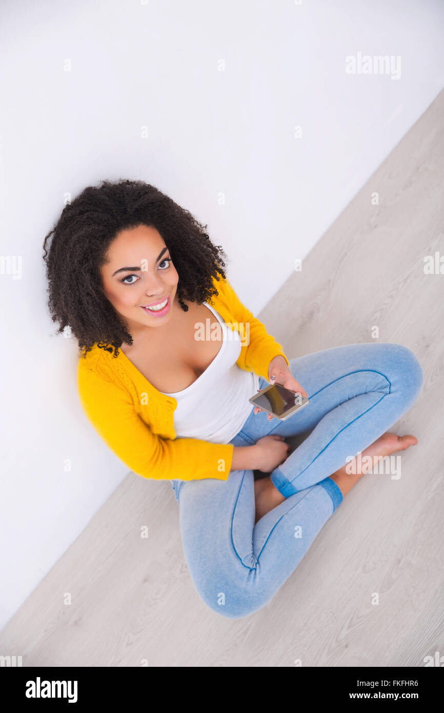Angenehme Mulatte Frau auf dem Boden sitzend Stockfoto