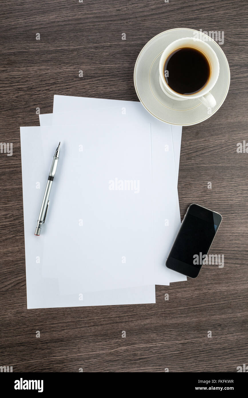 Smart Phone, Papier und Zeichenstift mit Kaffee auf dem Schreibtisch Stockfoto