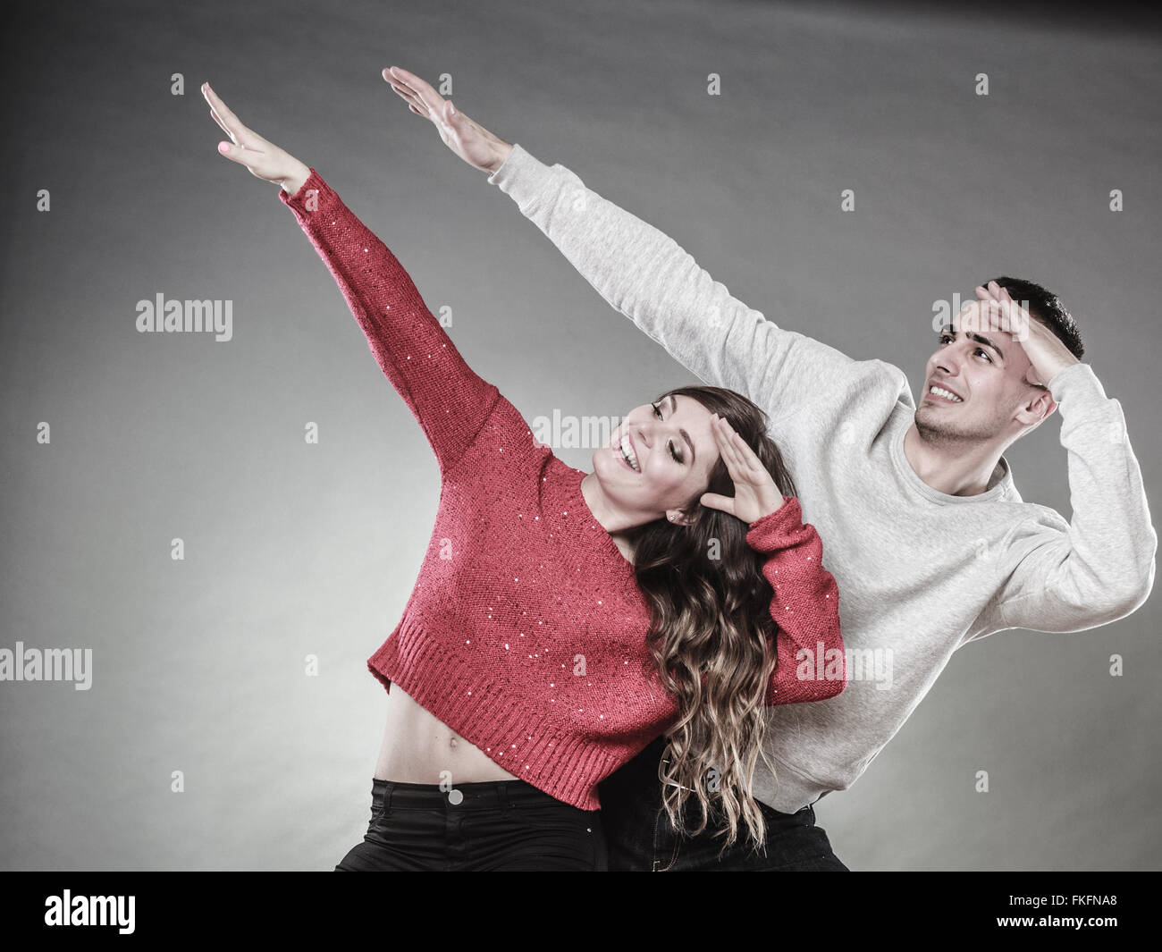 Liebe, Freundschaft und Glück Oncept. Lächelnde junge Paare, die haben Spaß, glücklicher Mann und Frau-Studio am grau erschossen Stockfoto