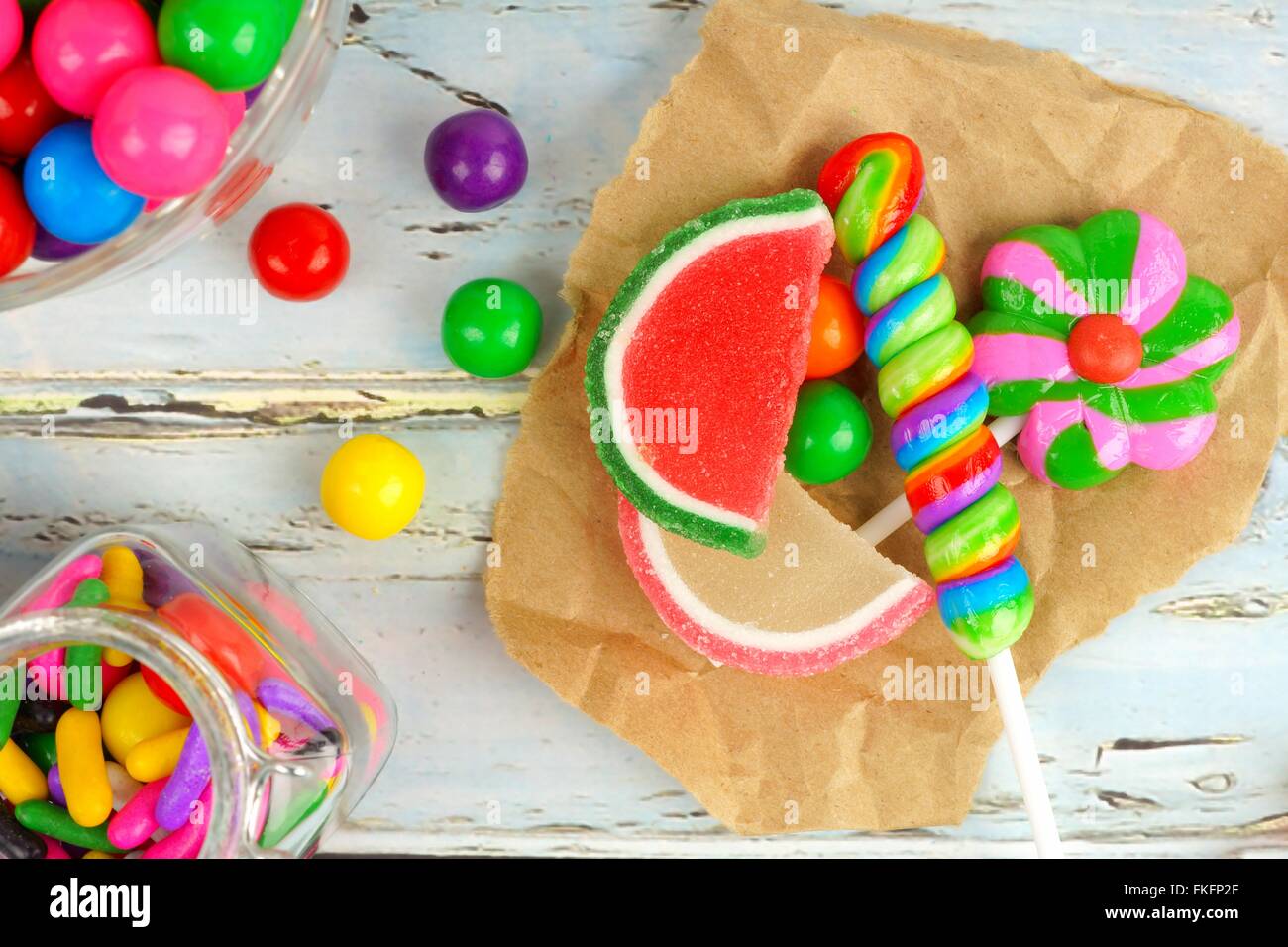 Sortiment an süßen Bonbons in einem Cluster auf dem Papier mit rustikalen Holz Hintergrund Stockfoto