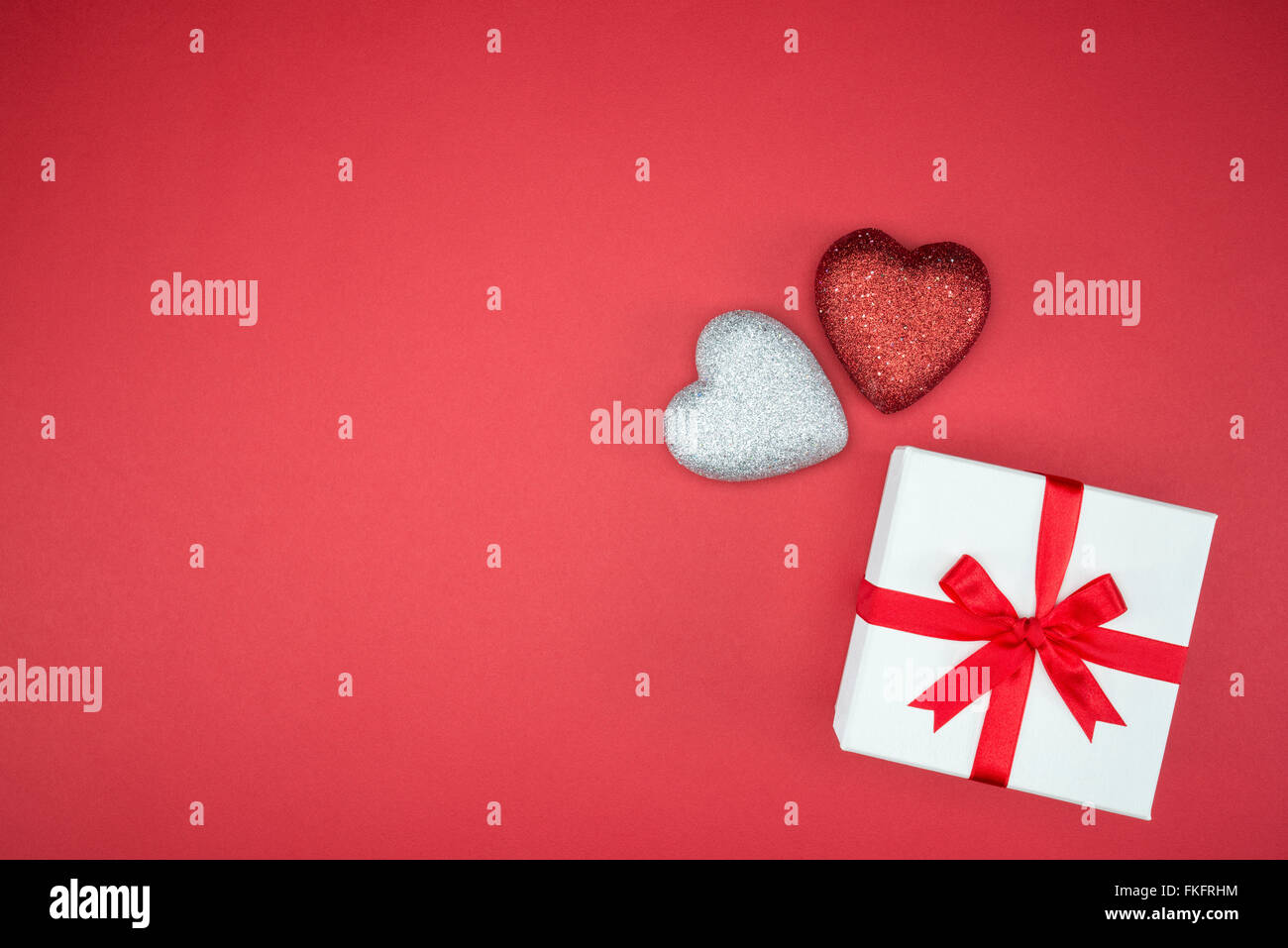 Geschenk Box Wrap Seidenband mit Liebe Herzform auf rotem Grund Stockfoto