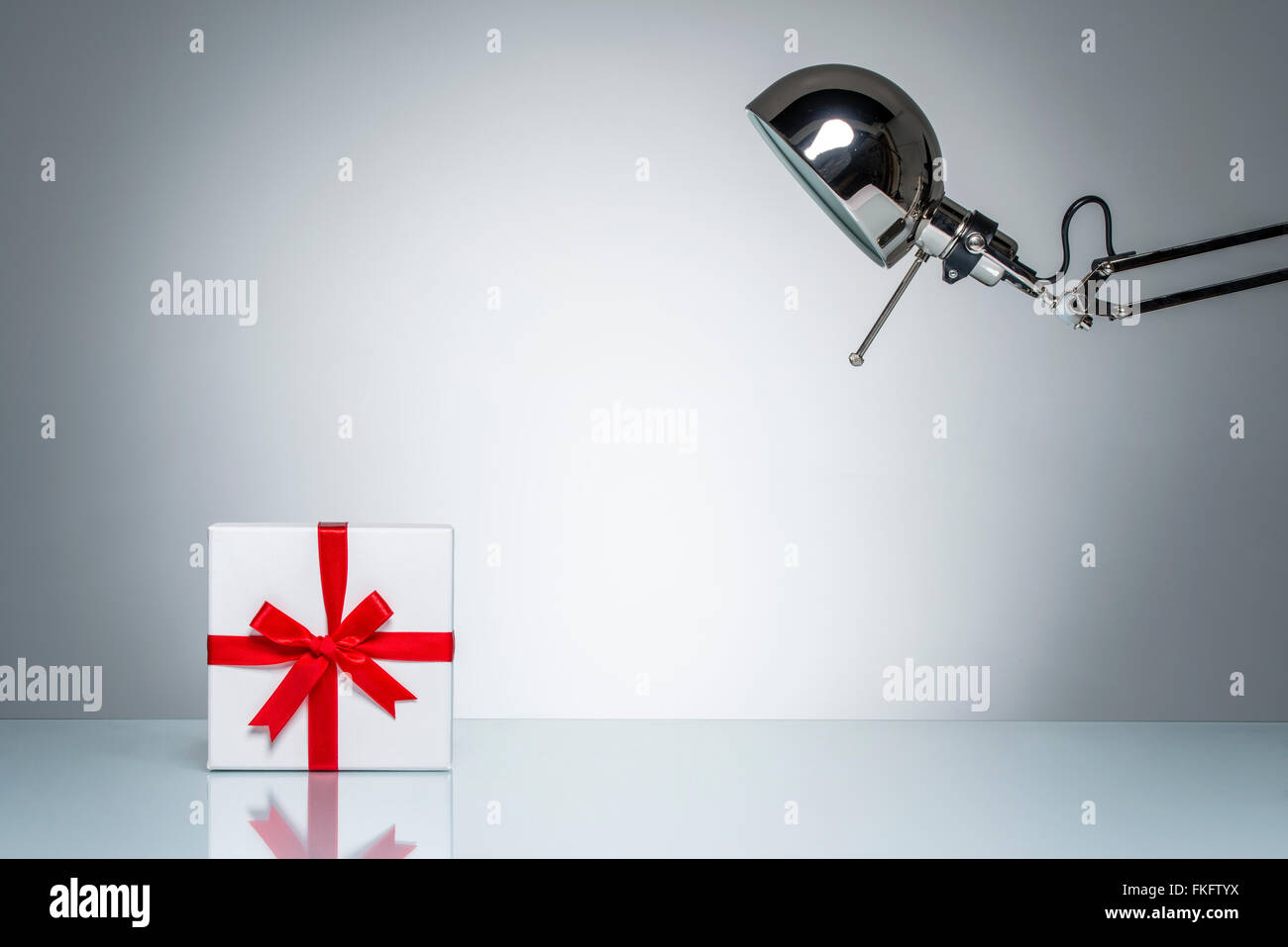 Geschenk-Box vorhanden aufleuchten mit Schreibtischlampe auf Runde Studiobeleuchtung Stockfoto