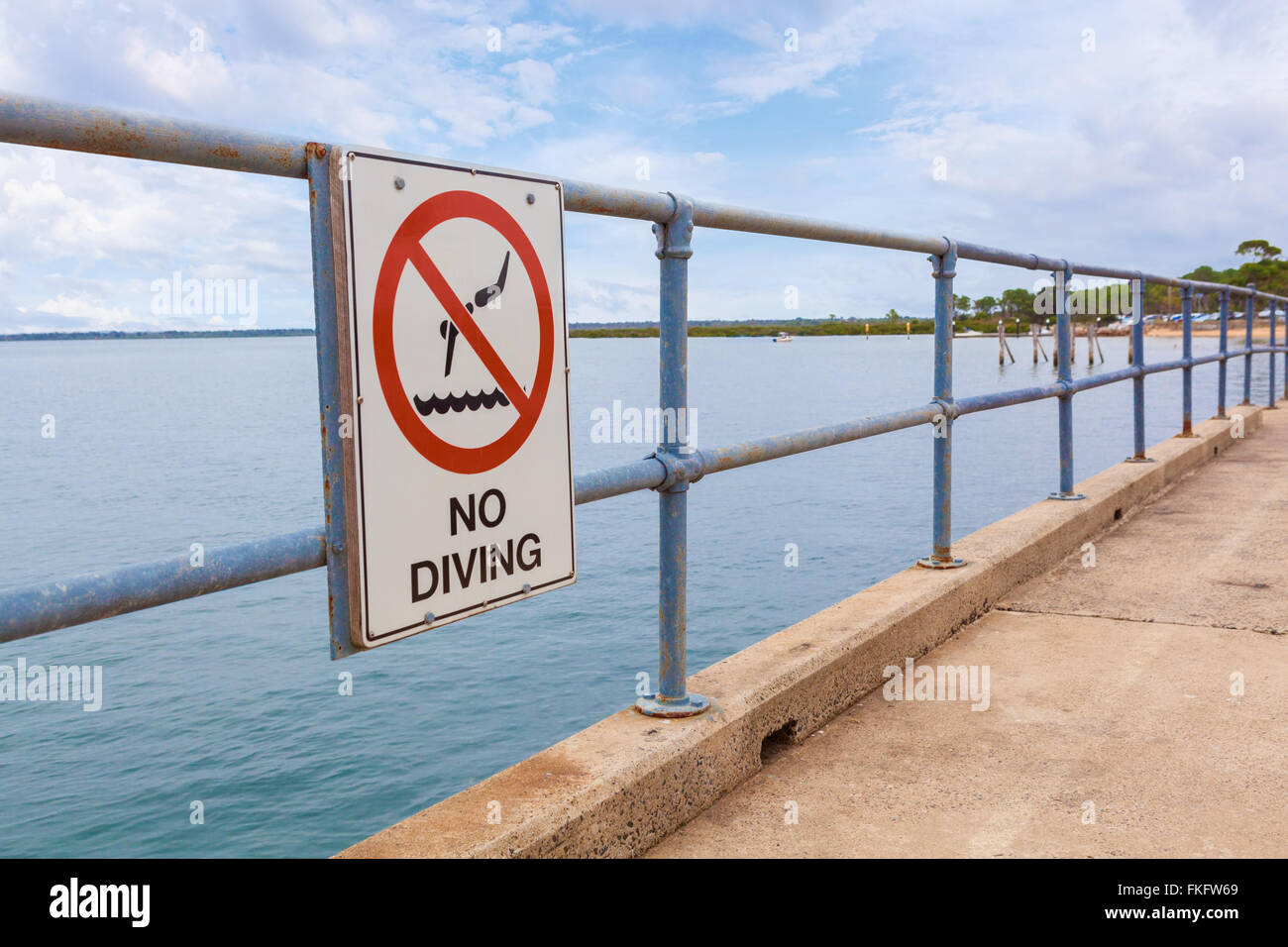Kein Tauchen Zeichen auf einem Pier Geländer mit Meerwasser im Hintergrund Stockfoto