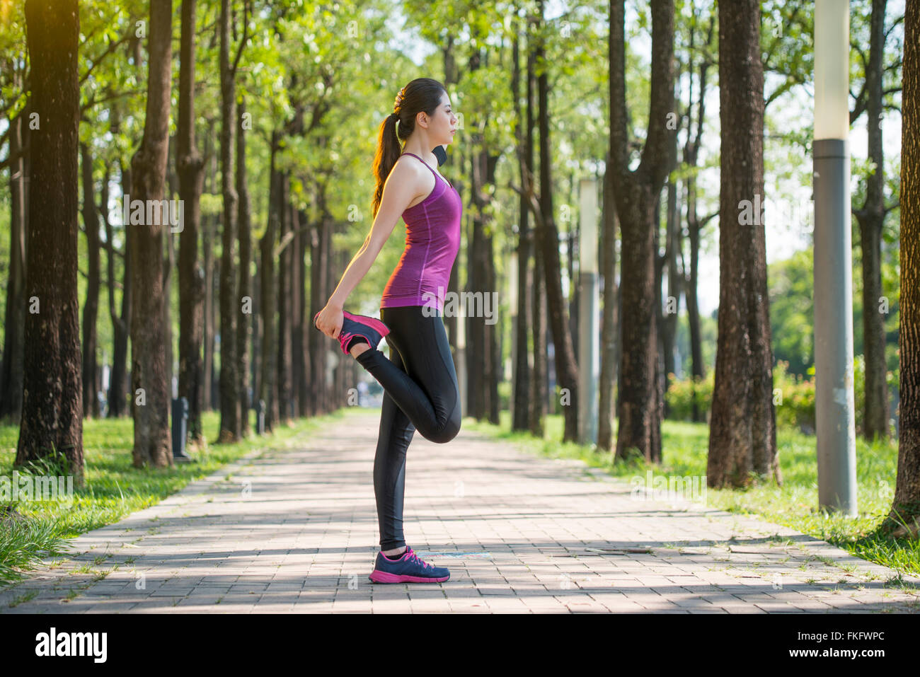 Sportliche junge Asiatin Dehnung nach dem Joggen im Wald, Lebensstil Stockfoto