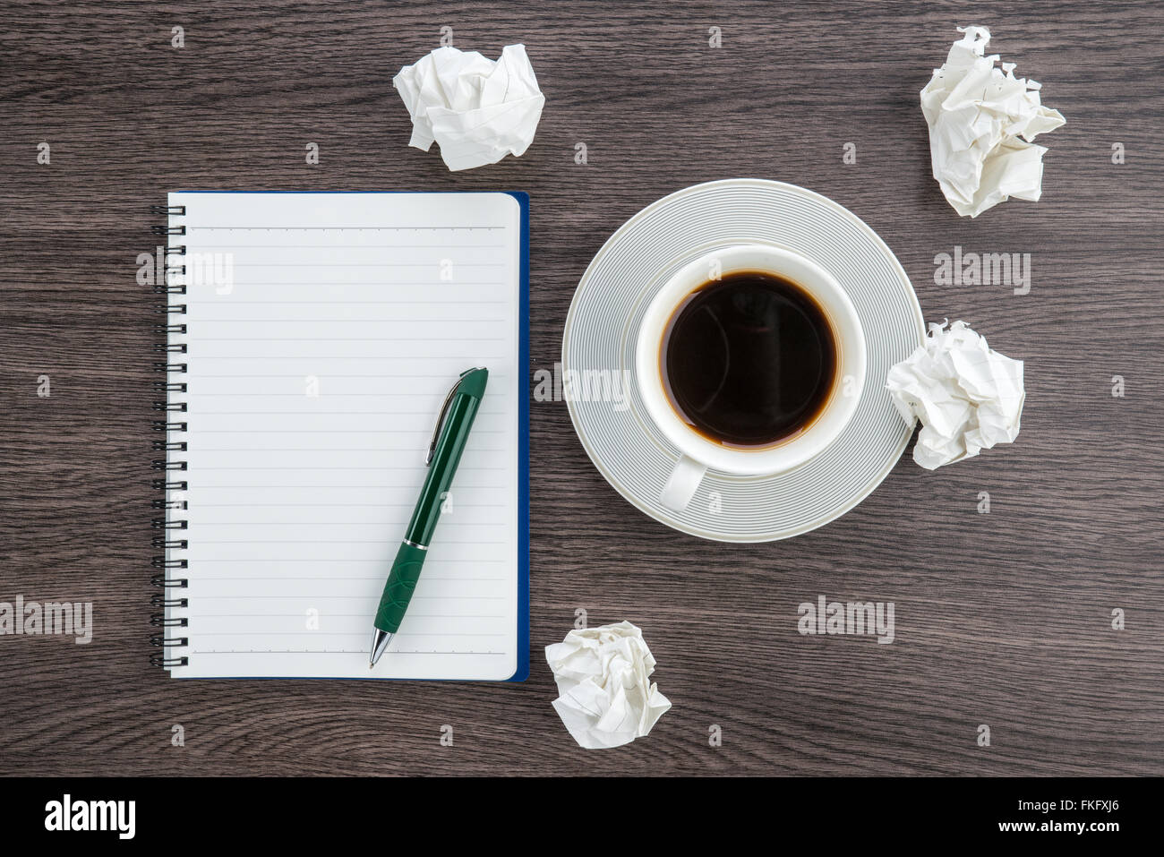 knüllen Sie Papier, Notizbuch und Stift mit Tasse Kaffee auf dem Schreibtisch Stockfoto