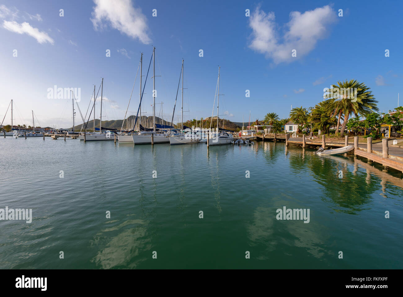 Yachten und Motorboote verankert im kristallklaren, türkisfarbenen Wasser in der Karibik Stockfoto