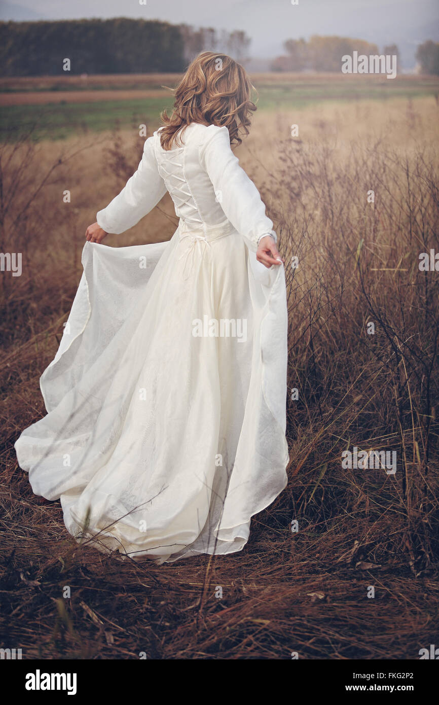 Frau mit Vintage-Kleid in trockenen Bereichen. Romantik und Reinheit Stockfoto