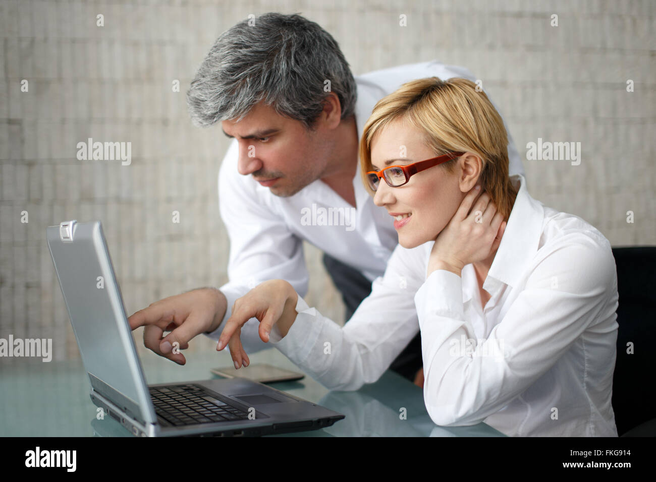 Junge Geschäftsleute über einen Laptop-Computer, Lächeln, Geschäftsfrau Stockfoto