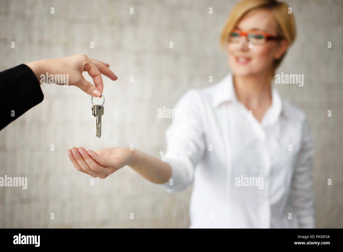 Glückliche Besitzer übergeben Schlüssel vom Haus in Büro, Real estate Stockfoto