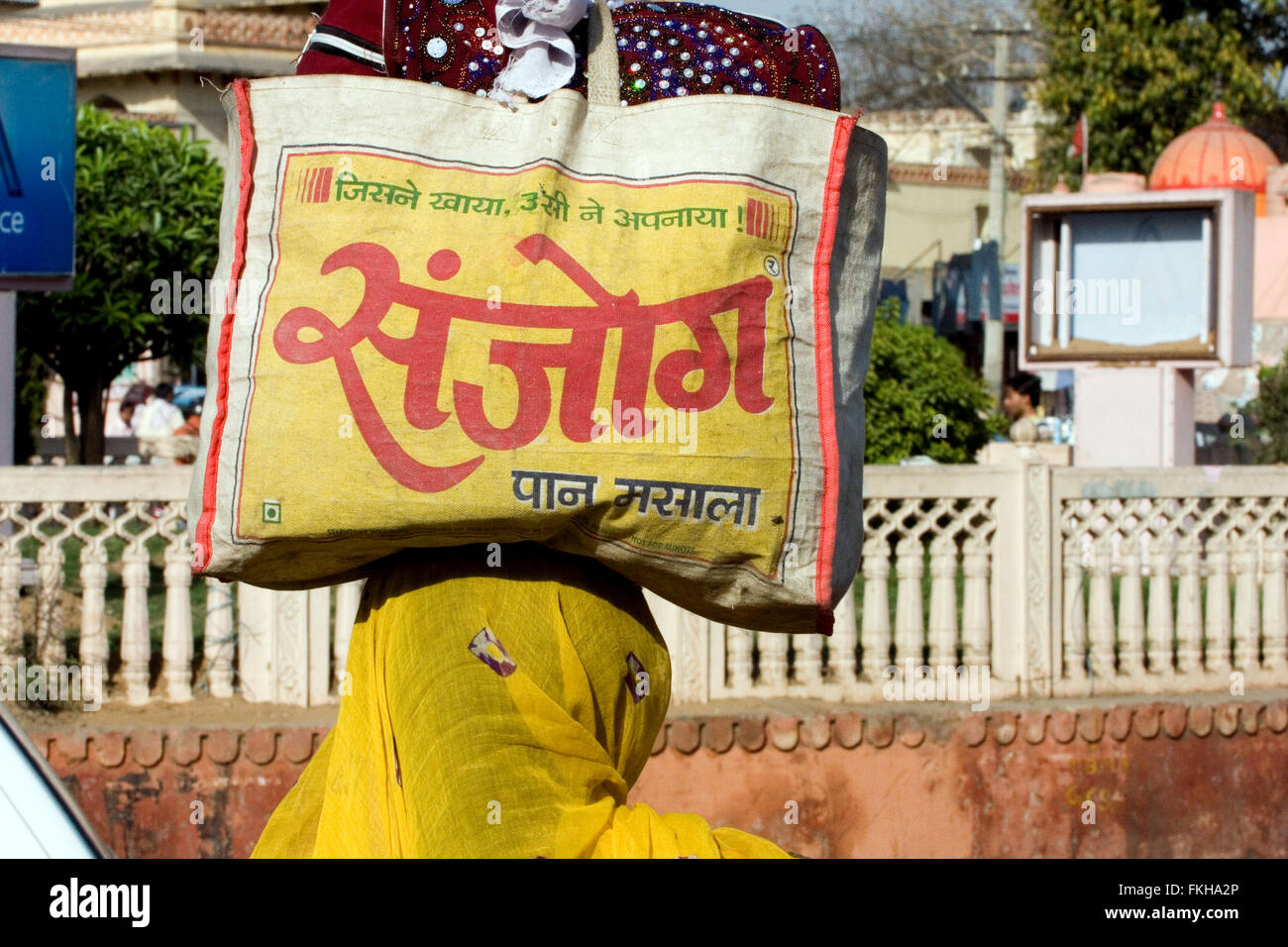 Frau im Sari Saree Headloading Tragetasche mit Hindu-Skript auf dem Kopf in Jaipur, Rajasthan, Indien, Asien. Stockfoto