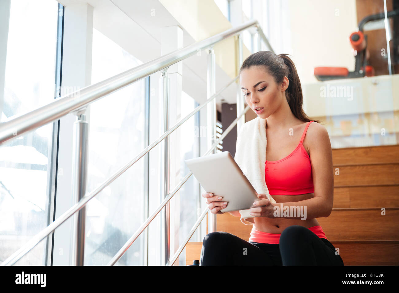 Thougtful hübsche junge Sportlerin mit Tablet nach dem Training im Fitness-Studio Stockfoto