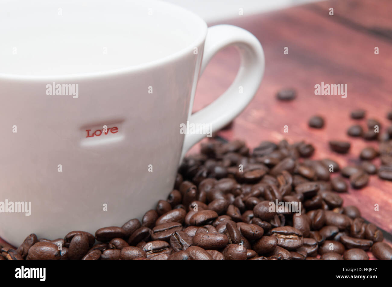 Stark gewürzte Kaffee Bohnen in eine schlichte weiße Tasse Stockfoto