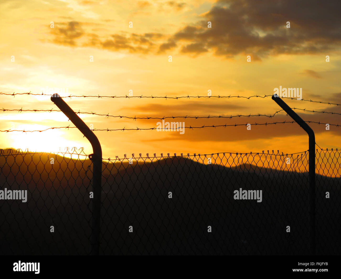 Stacheldrahtzaun gegen Sonnenaufgang in Alora Landschaft, Andalusien Stockfoto