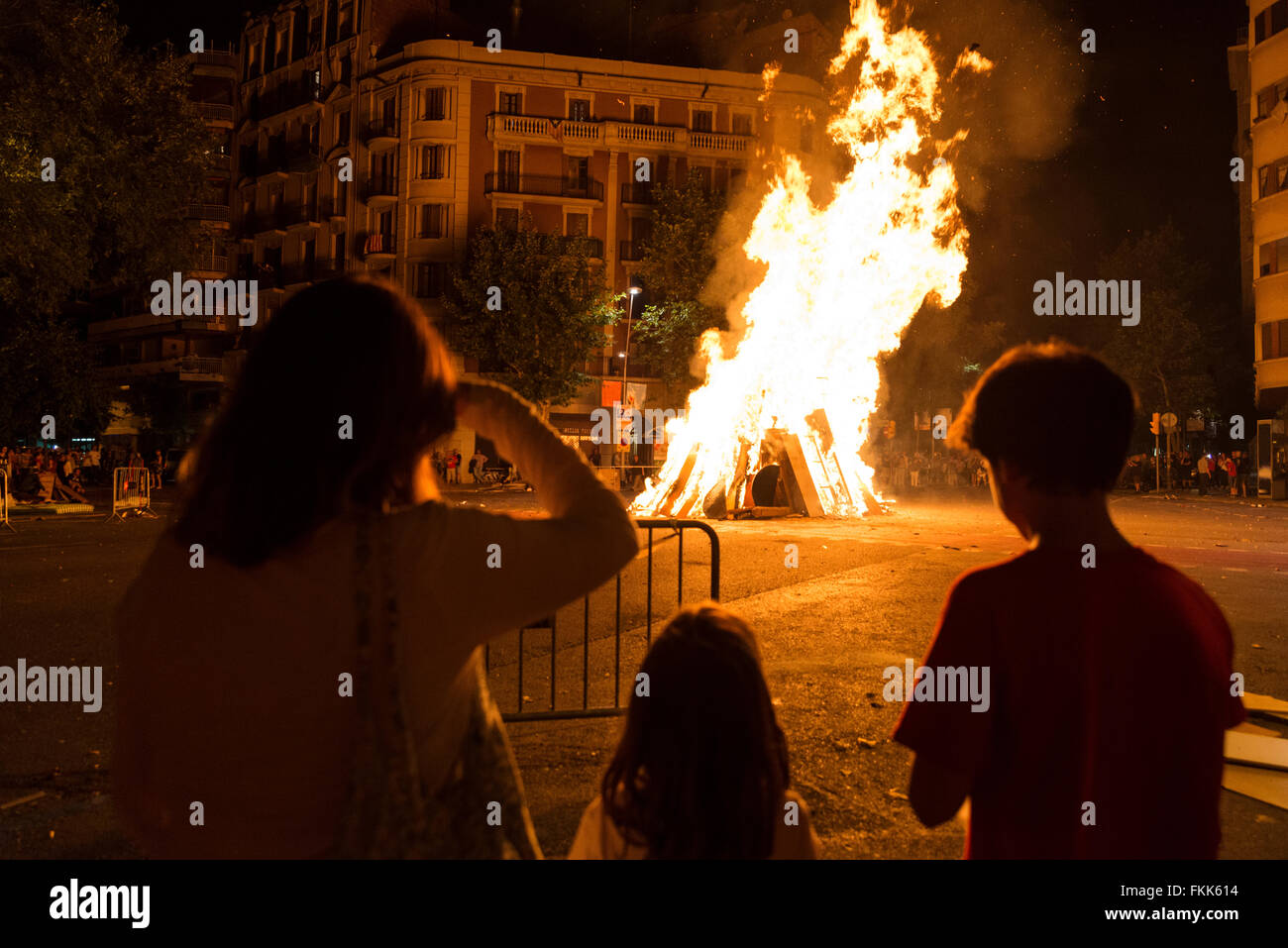 Familie bei einem Lagerfeuer in der Nacht auf das Fest von Sant Joan auf einer Straße in Barcelona, Katalonien, Spanien Stockfoto