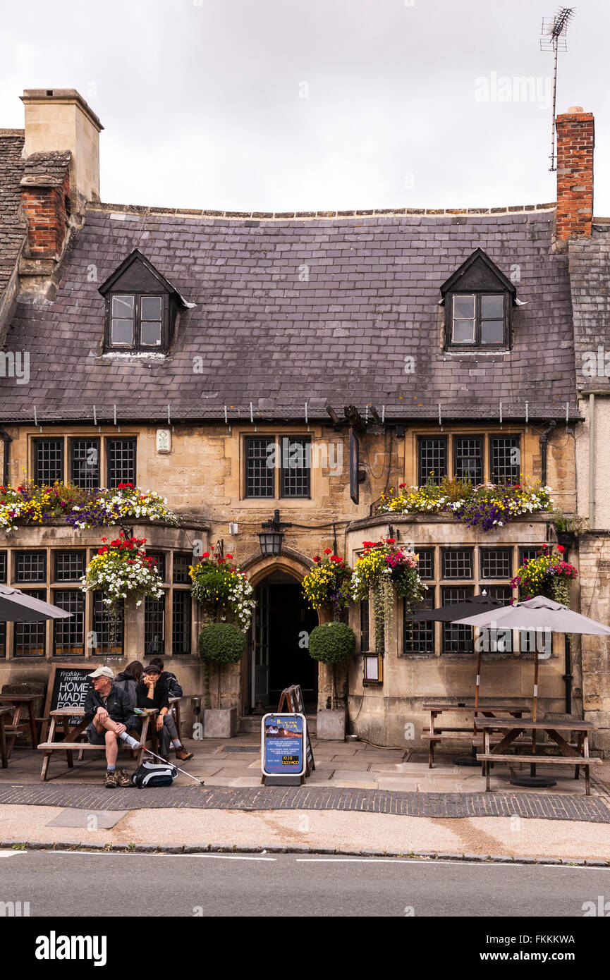 Touristen sitzen vor einem Pub in Burford, Oxfordshire, England, Großbritannien, Uk Stockfoto