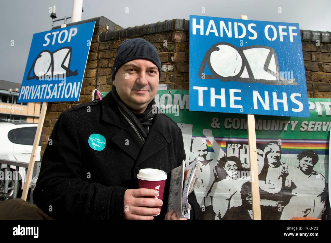 48-Stunden-Streik der Junior Ärzte, Homerton Hochschule Hospital.A junior Arzt mit Plakaten eines Babys von Stik. Stockfoto