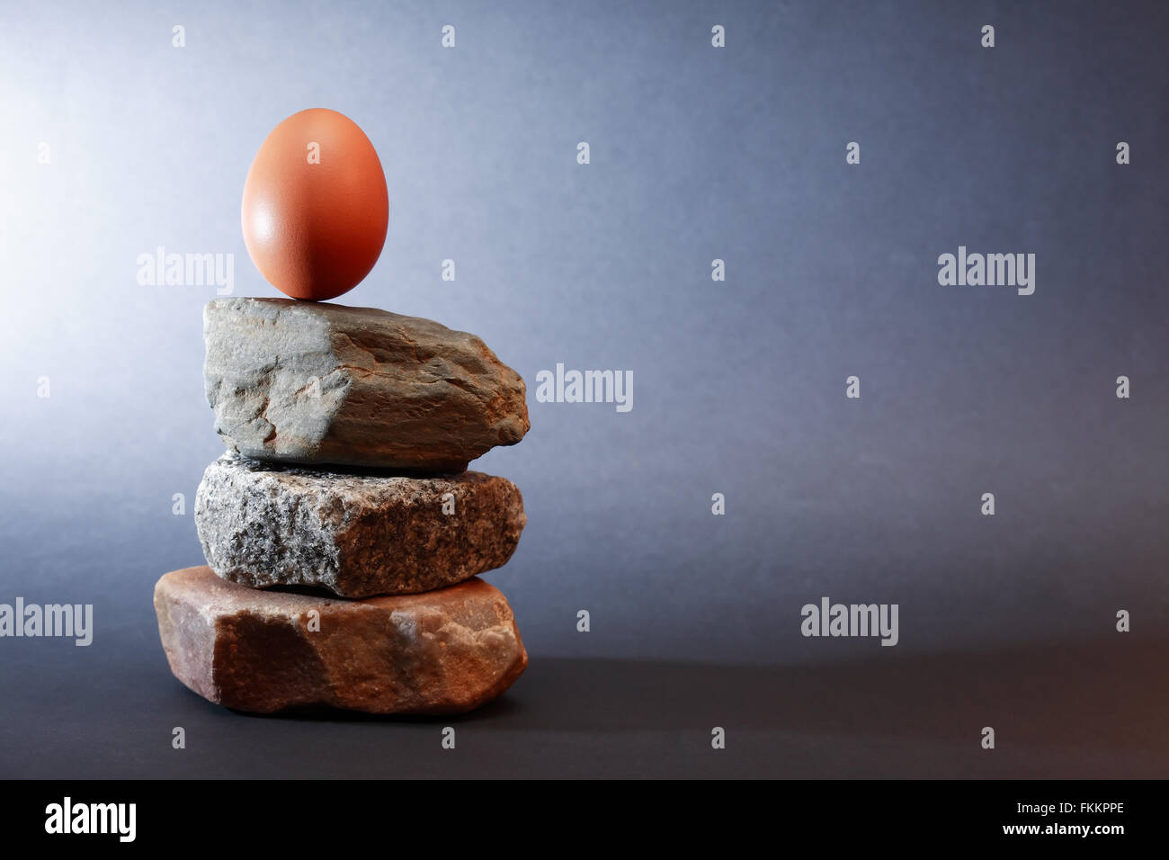 Balance-Konzept. Ei auf Steinen Pyramide stehend Stockfoto
