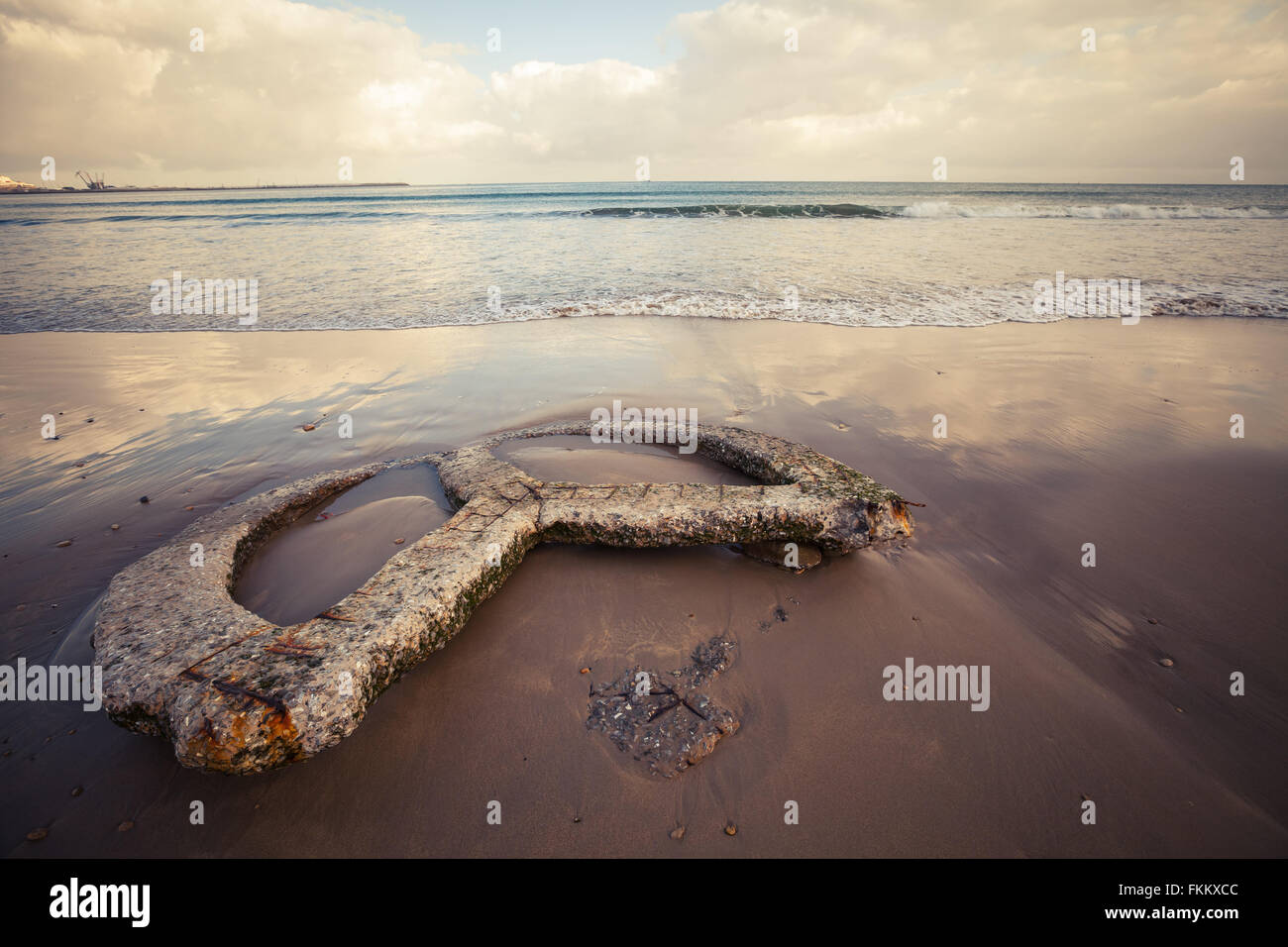 Atlantik Küste legt alten gebrochenen Betonbau auf nassen Sand, Strand von Tanger, Marokko. Warmer Retro-Tonwertkorrektur Stockfoto