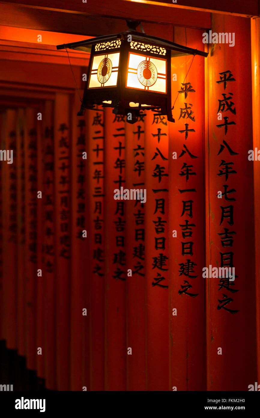 Laterne beleuchtet die Namen eingraviert auf der Torii des Fushimi Inari-Taisha, Fushimi-Ku, Kyoto, Japan. Stockfoto
