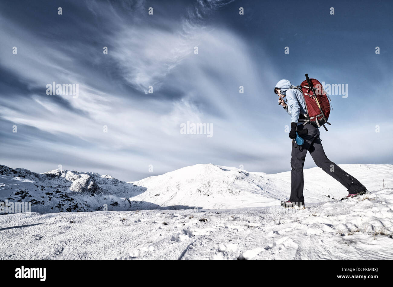 Eine Übernahme von Flüssigkeiten während des Gehens in den Bergen im Winter wandern. Zusätzlichen Filmkorn und Farbe-Styling. Stockfoto