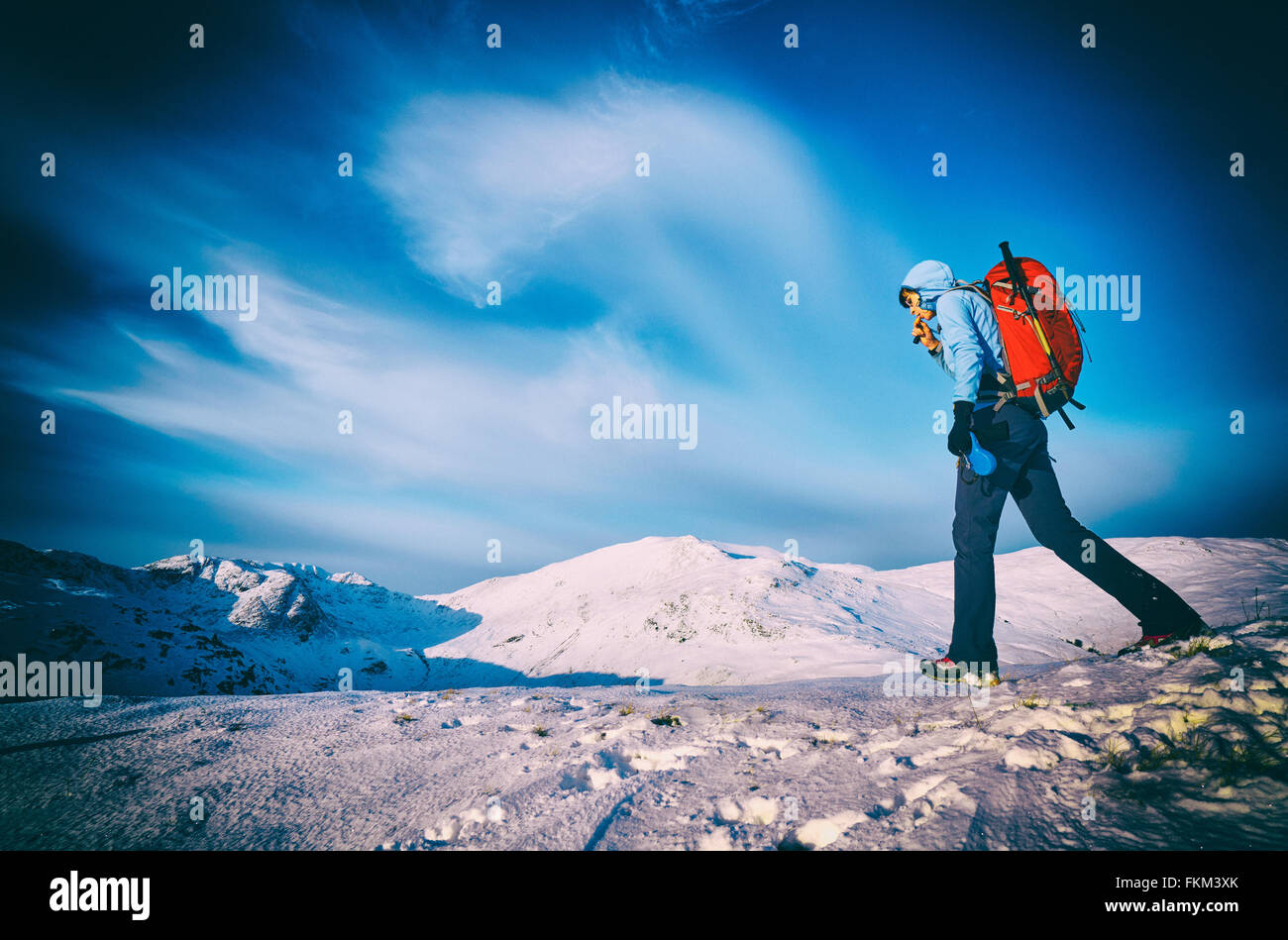Eine Übernahme von Flüssigkeiten während des Gehens in den Bergen im Winter wandern. Zusätzlichen Filmkorn und Farbe-Styling. Stockfoto