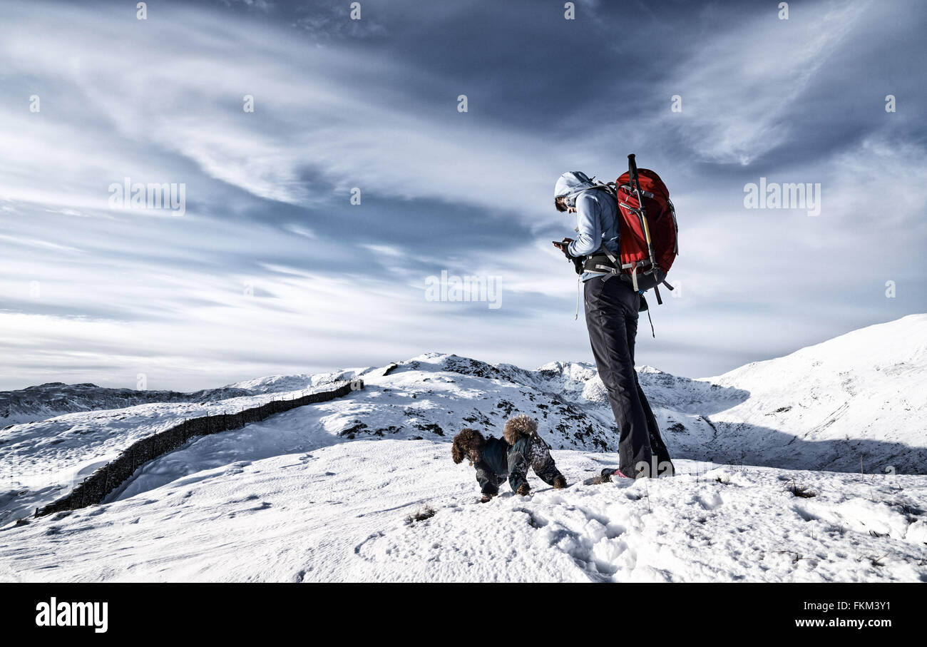 Ein Wanderer Überprüfung ihre Position in den Bergen auf einem GPS und Karte. Zusätzlichen Filmkorn und Farbe-Styling. Stockfoto