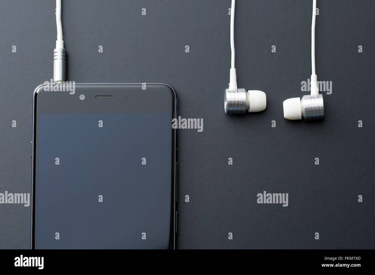 Kopfhörer und Handy auf schwarzem Hintergrund Stockfoto