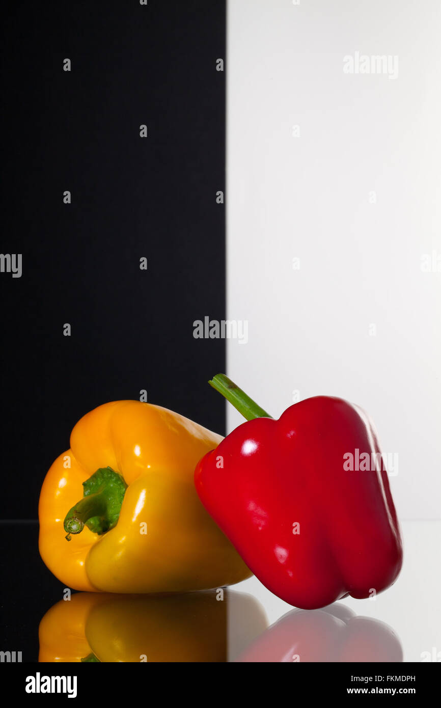 Zwei Paprika isoliert auf schwarzen und weißen Hintergrund und Glas Schreibtisch Stockfoto