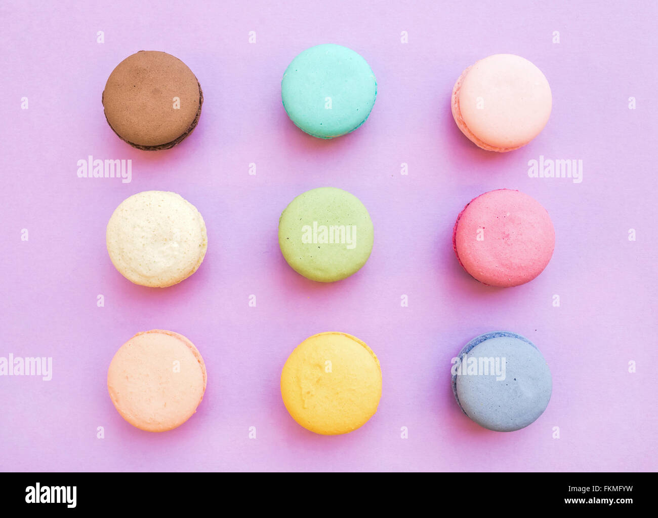 Süße bunte französische Macaron Kekse auf Pastell rosa Hintergrund, Ansicht von oben Stockfoto