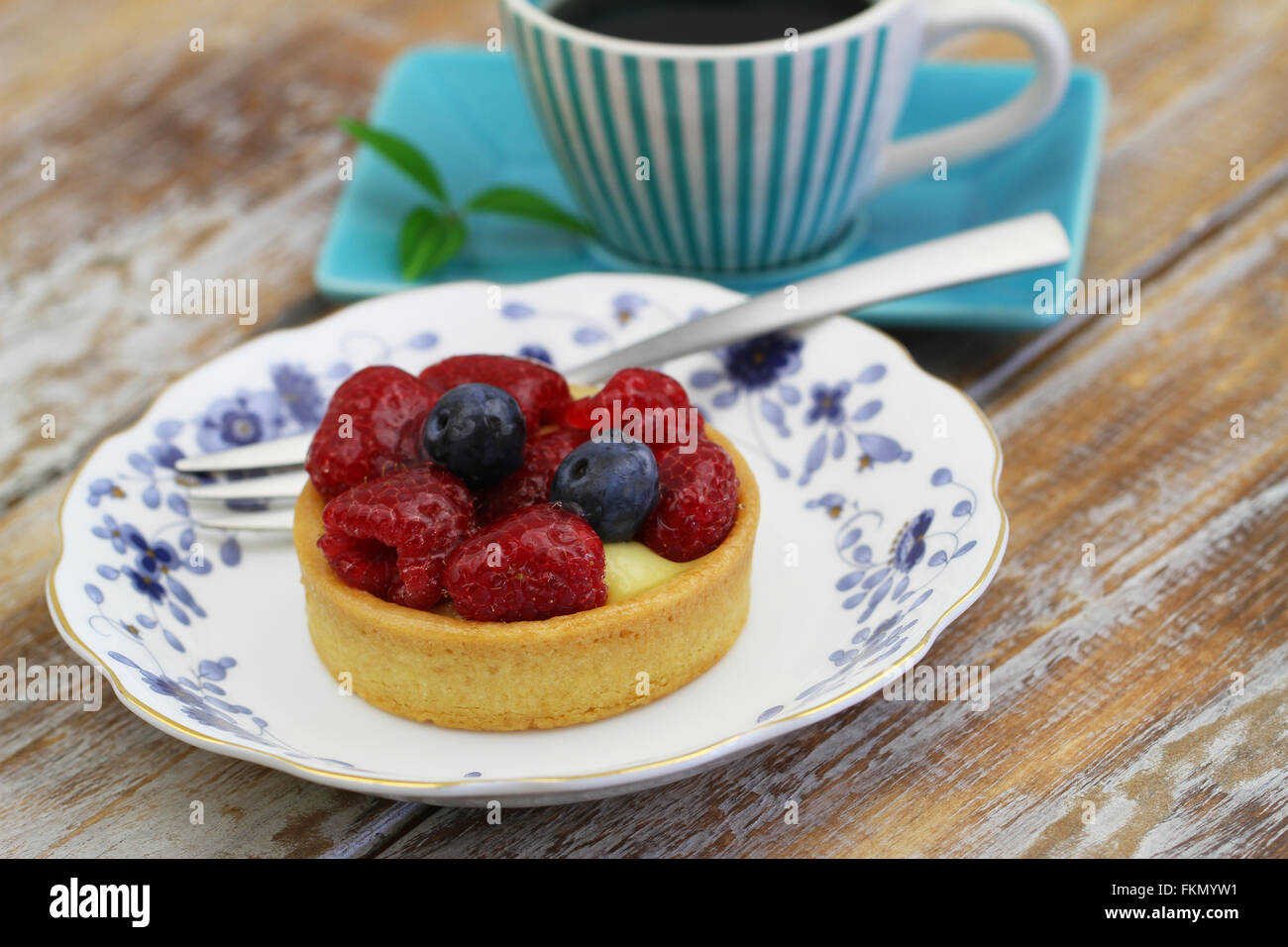 Sahne-Torte mit Vanillecreme und frischen Erdbeeren und Heidelbeeren auf Vintage Teller Stockfoto