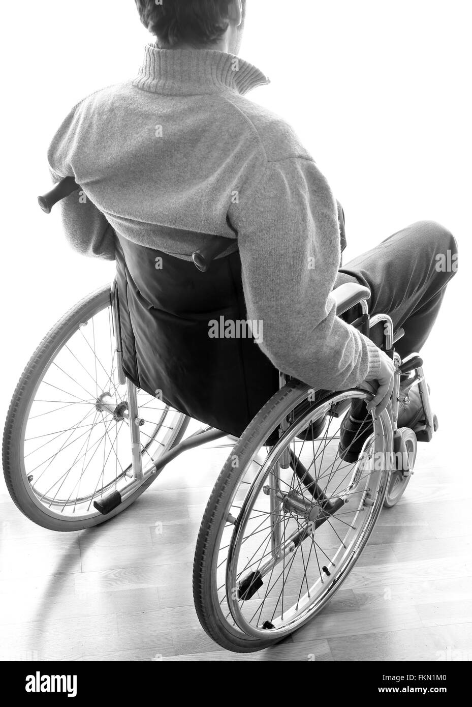 Behinderte, ältere Menschen sitzen in einem Rollstuhl in den Raum vor dem Fenster Stockfoto