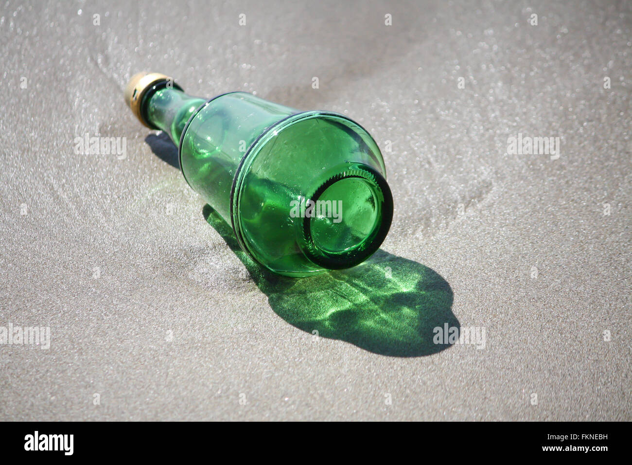 Grüne Flasche am Strand verloren Stockfoto