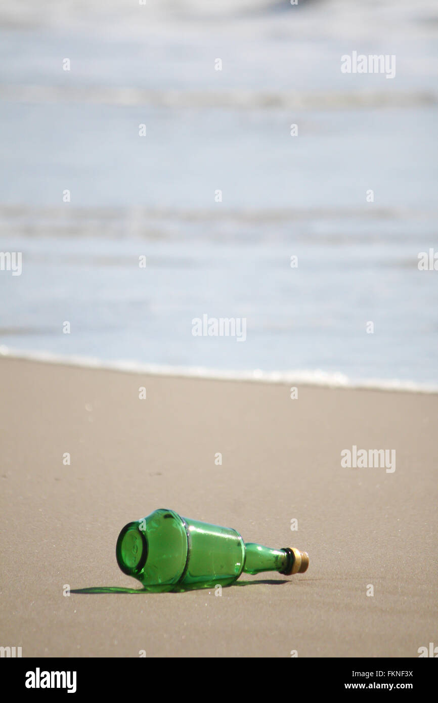 Grüne Flasche am Strand verloren Stockfoto
