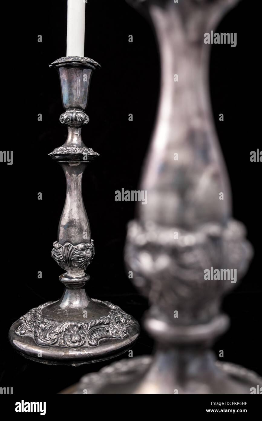 Antik Silber-Leuchter mit einer weißen Kerze isoliert auf einem schwarzen Hintergrund und selektiven Fokus Stockfoto
