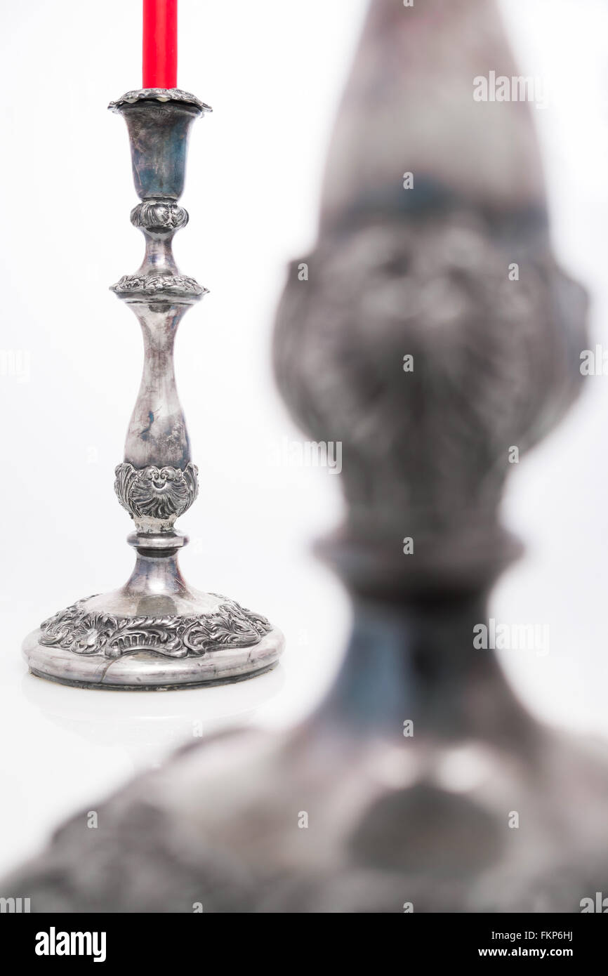 Antike verzierte Silber Leuchter mit einer roten Kerze isoliert auf einem weißen Hintergrund und selektiven Fokus Stockfoto