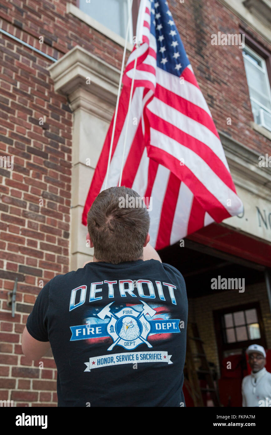 Detroit, Michigan - ein Feuerwehrmann senkt die Flagge am Ende eines langen Tages Detroits Feuerwache #3. Stockfoto