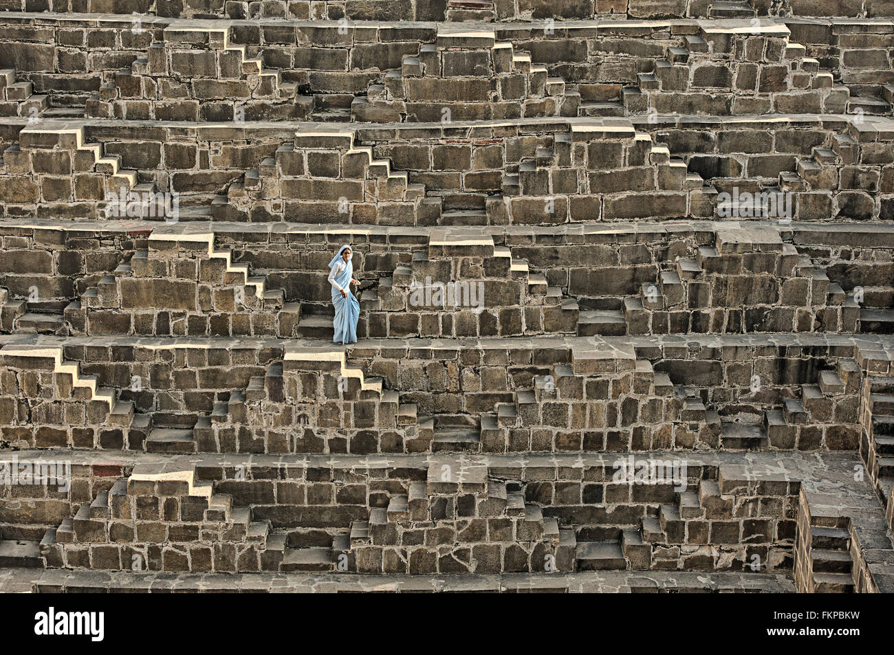 Unbekannten Menschen vor Ort überqueren die stepping-Stone innen Chand Baori Abaneri. Stockfoto