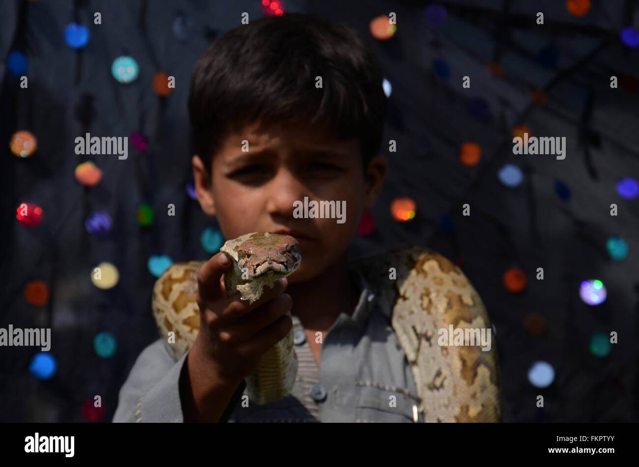 Lahore, Pakistan. 9. März 2016. Ein wenig Jongleur führt mit seiner Schlange während der "Hazrat Shaikh Syed Daud Bandagi Kirmani Sarkar", es ist ein jährliches Festival von Urs. Tausende von Gläubigen begann nach Pakistan zu reisen durch barfuß an Urs Festival drei Monate vor der Feier mit ihnen sind religiöse Flaggen fest geglaubt, dass ihre Hoffnungen fruchtbar sein werden durch die Gnade Gottes. © Rana Sajid Hussain/Pacific Press/Alamy Live-Nachrichten Stockfoto