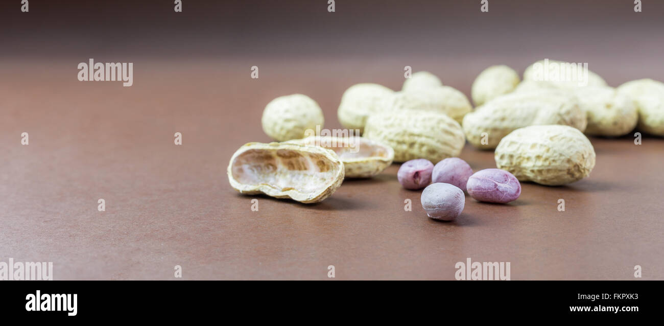 Erdnüsse mit Schale auf braunem Papier Stockfoto